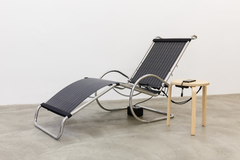 Alessandro Balteo-Yazbeck Comfort. From the series In Advance of the broken Model, 2019 Structure of Ludwig Mies van der Rohe's MR Adjustable Chaise Longe (designed ca. 1927) intervened with solar panels and electronic components connecting to Ikea Frosta-hack as Alvar Aalto stool 60 (designed 1933) and narrative label Dimensionen variabel, ca. 80 x 120 x 178 cm 